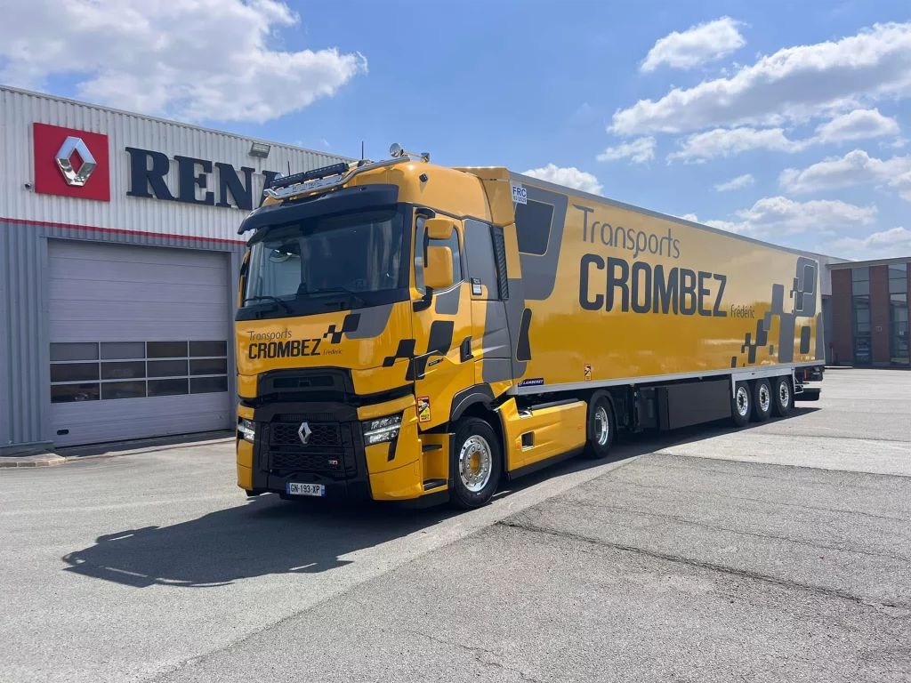 Photo camion de transport jaune renault devant un hangar