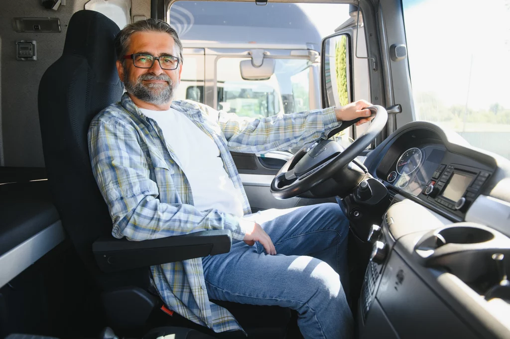 chauffeur poids lourd professionnel vue de côté dans la cabine du camion